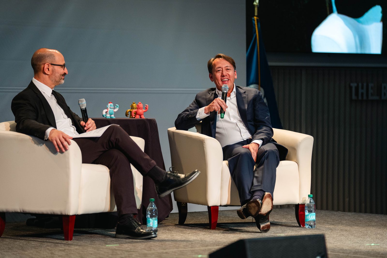 Two panelists sharing a laugh on stage